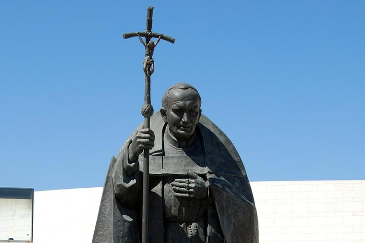 eine Statue eines Mannes, der ein Kreuz hält