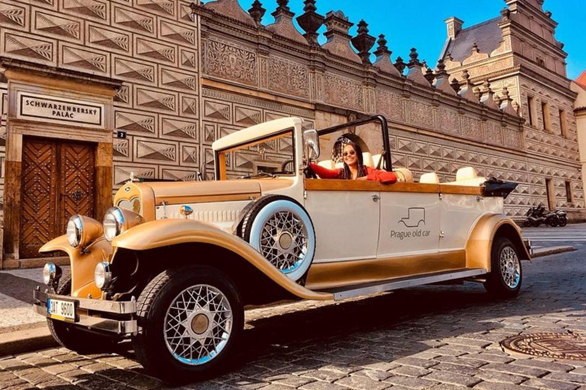 a woman driving an old car on a street