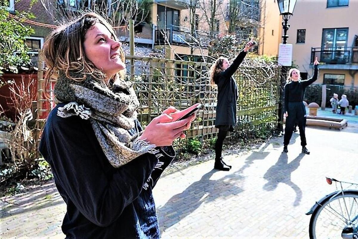 Una mujer parada en una acera mirando su teléfono celular