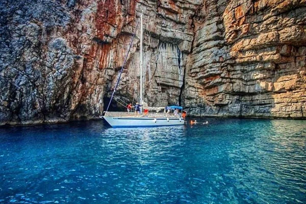 un barco en el agua junto a un acantilado