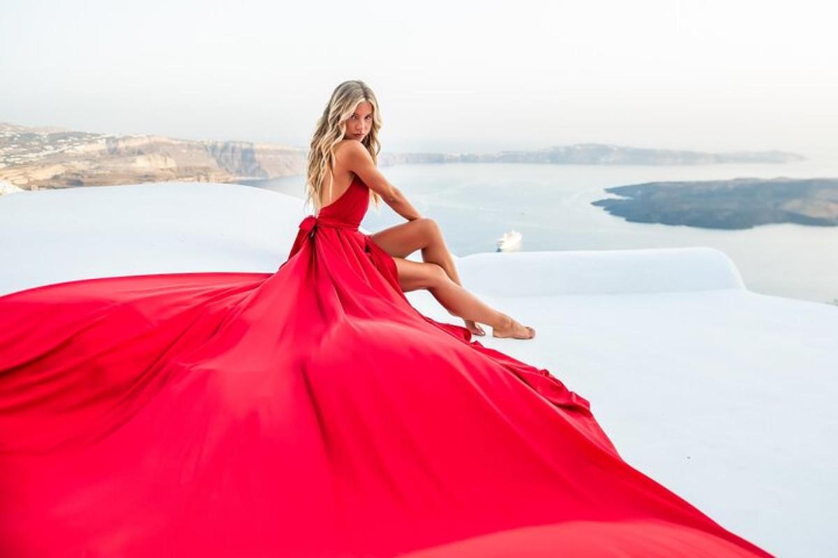 una donna in un vestito rosso seduta su una roccia