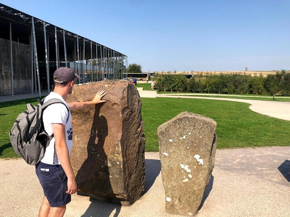 a man standing next to a large rock