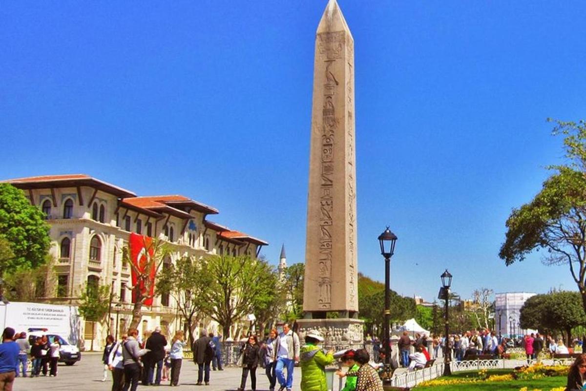 sekumpulan orang berdiri di sekeliling obelisk besar