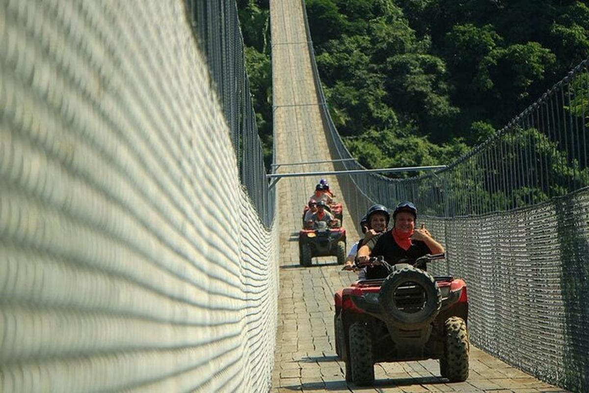 dues persones que viatgen en un quad sobre un pont penjant