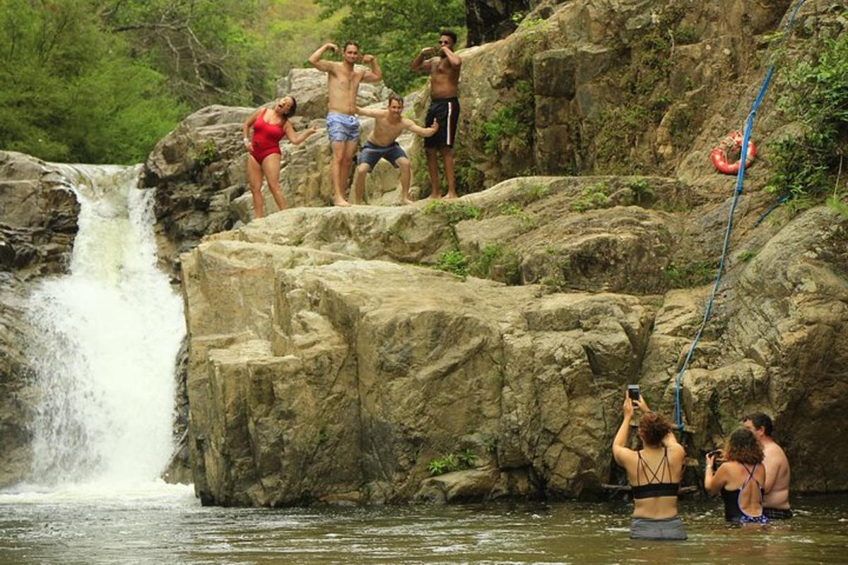 un grup de persones dempeus sobre roques prop d'una cascada