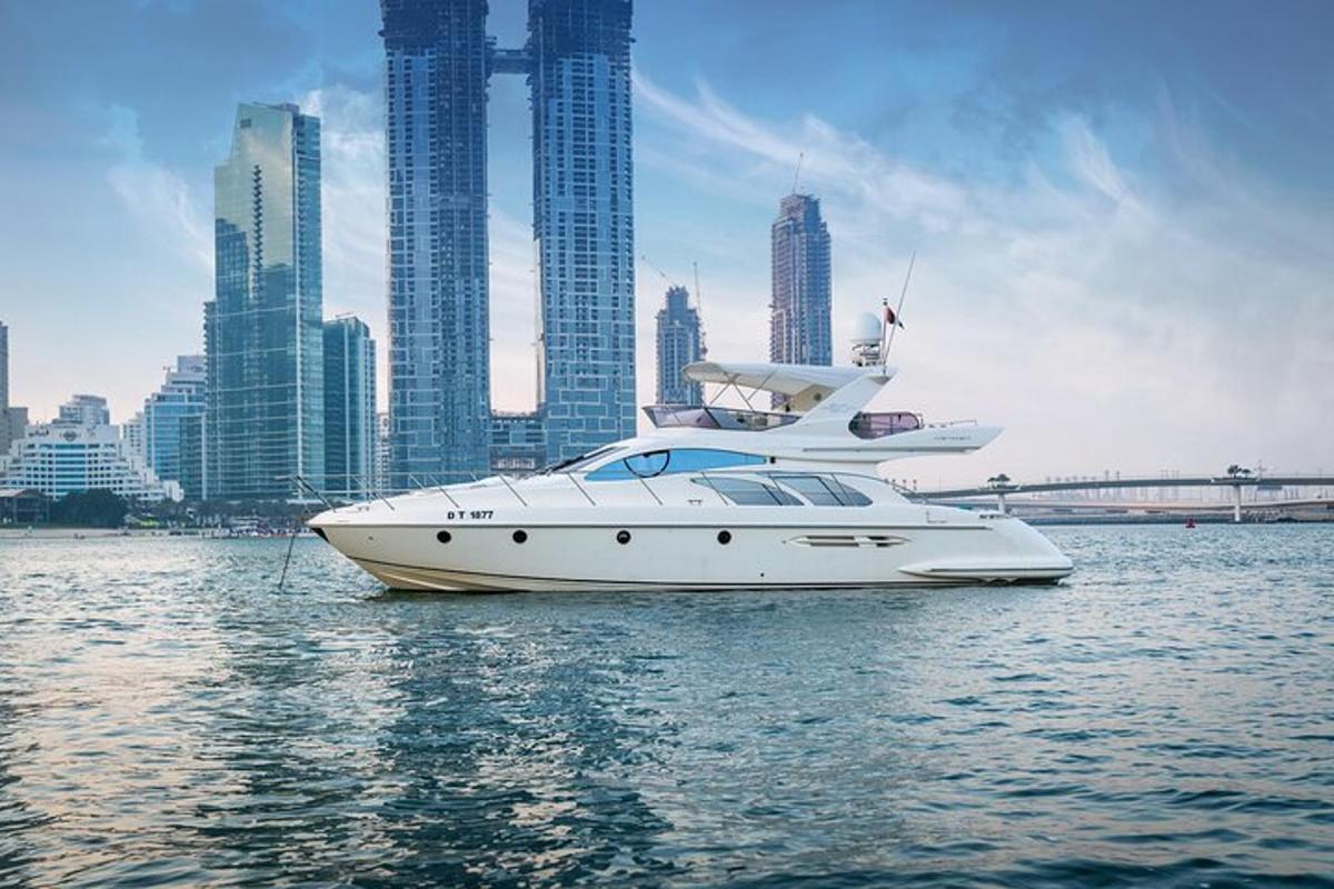 a white boat in the water in front of a city