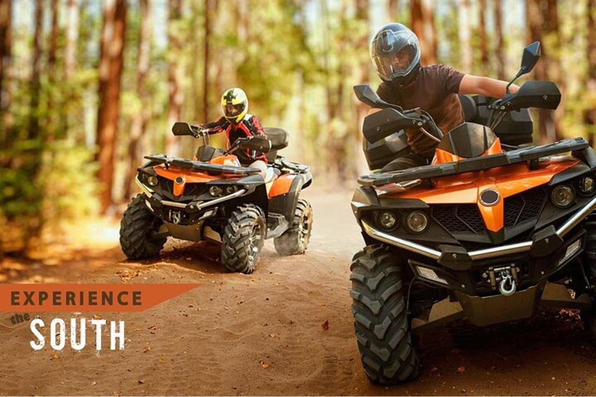 dues persones que viatgen en quads per un camí de terra