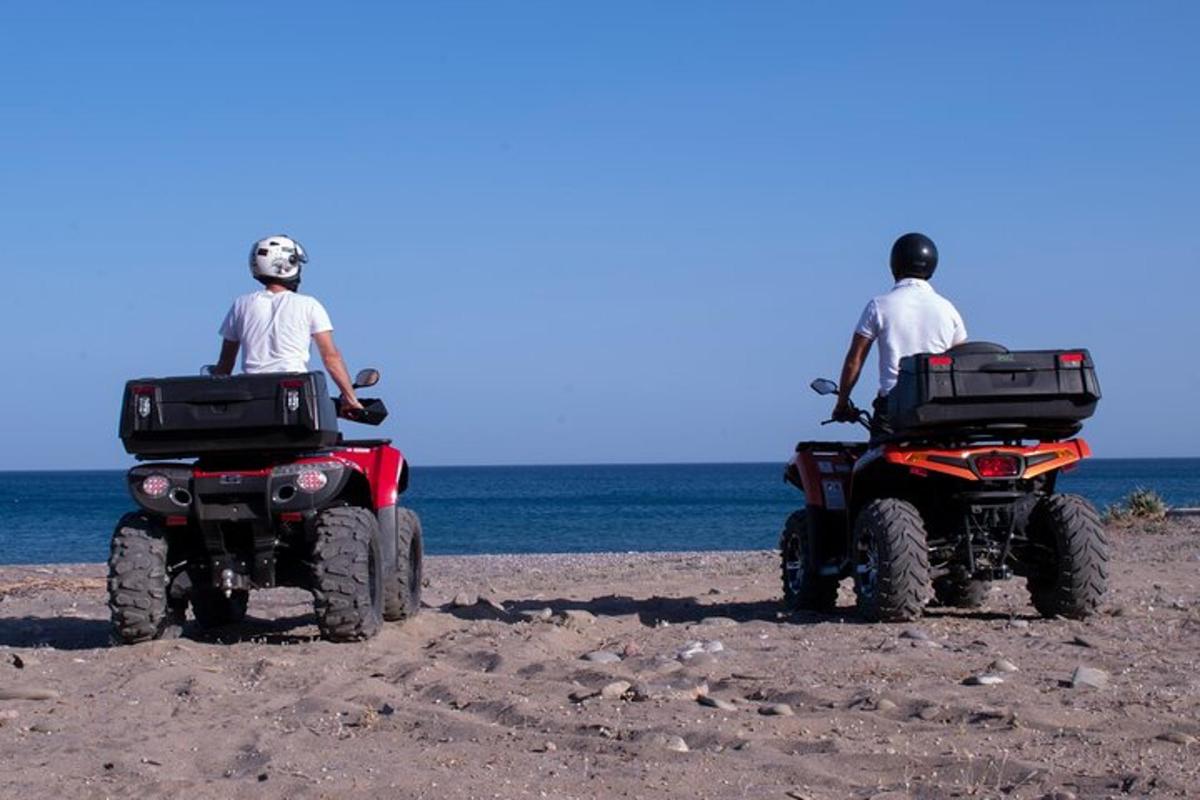 dos homes asseguts en quads a la platja