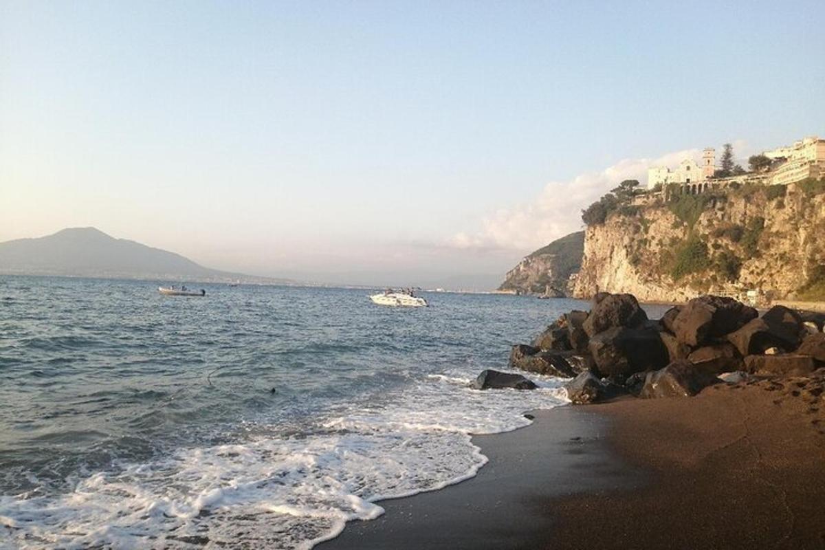 a beach with rocks and the water and a boat