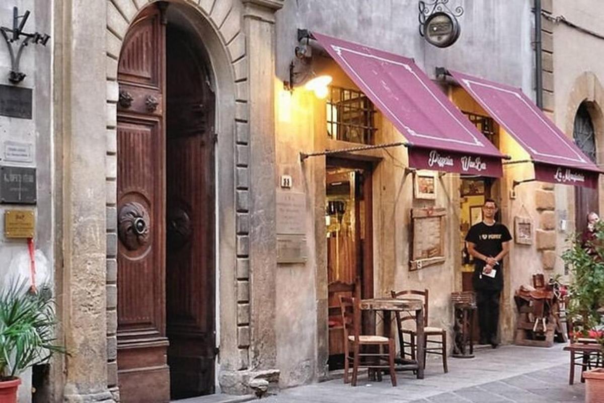 un home dret fora d'un edifici amb taules i cadires