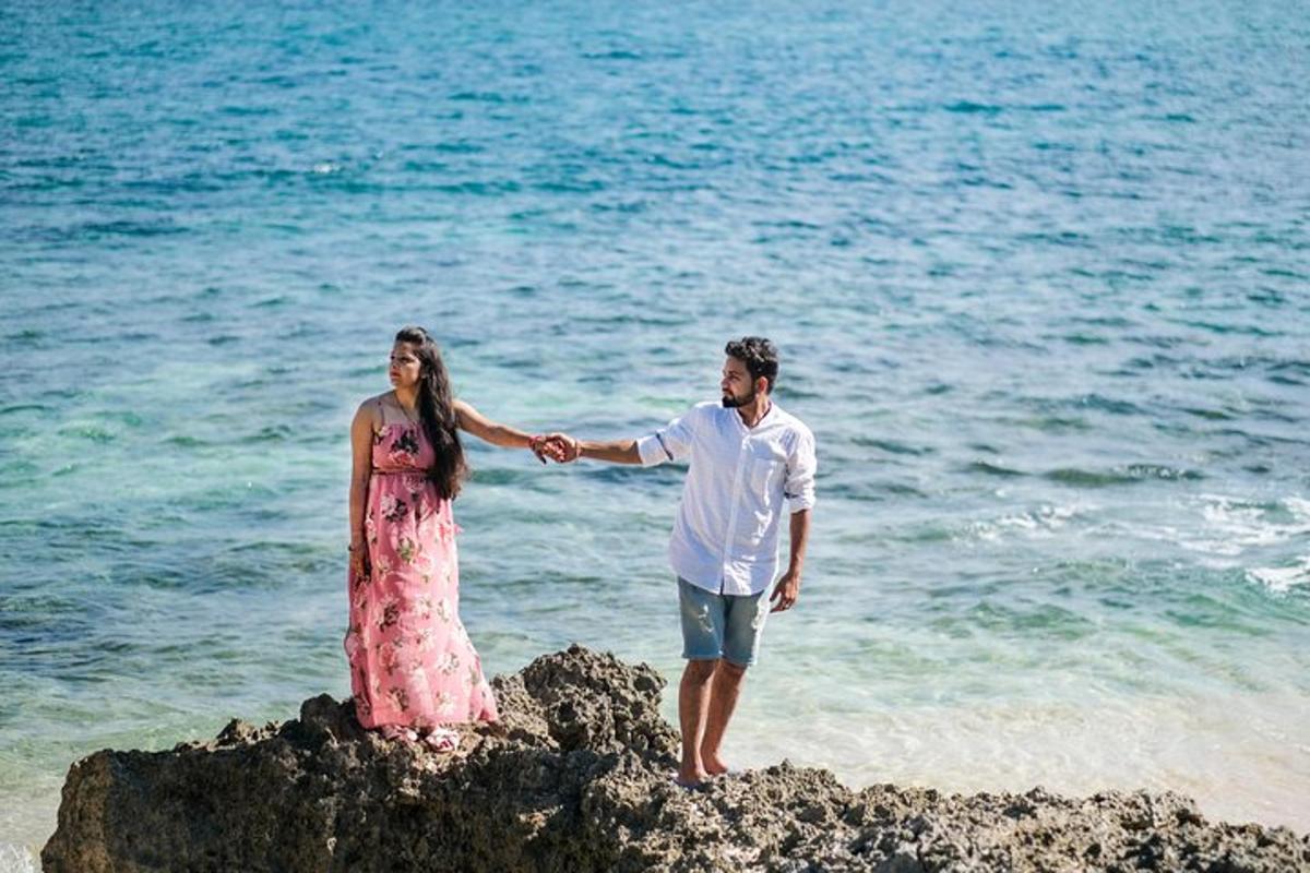Ένας άντρας και μια γυναίκα στέκονται σε έναν βράχο στην παραλία