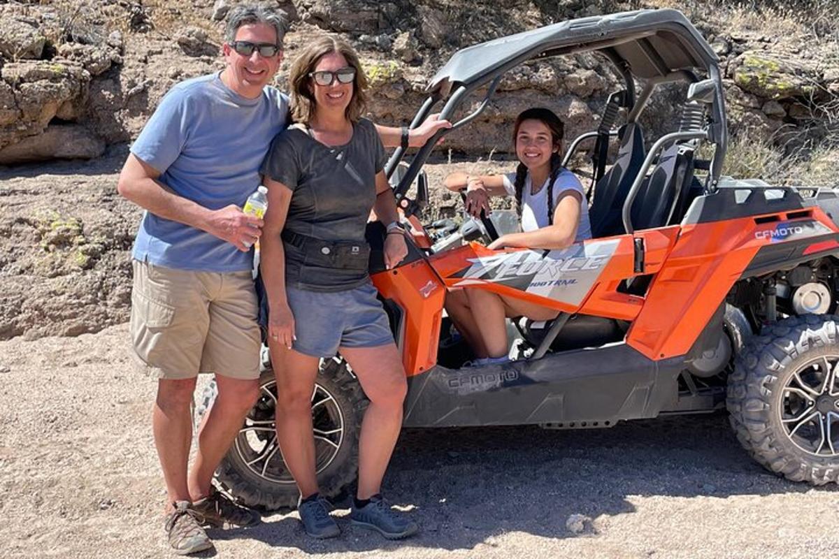a man and a woman standing in front of a four wheeler