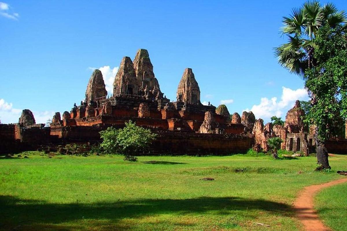 um grande edifício de pedra com uma palmeira em um campo