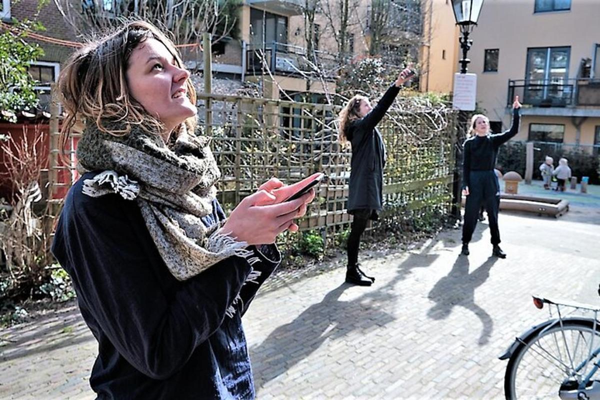 skupina žien stojacich na chodníku a pozerajúcich sa do svojich mobilných telefónov