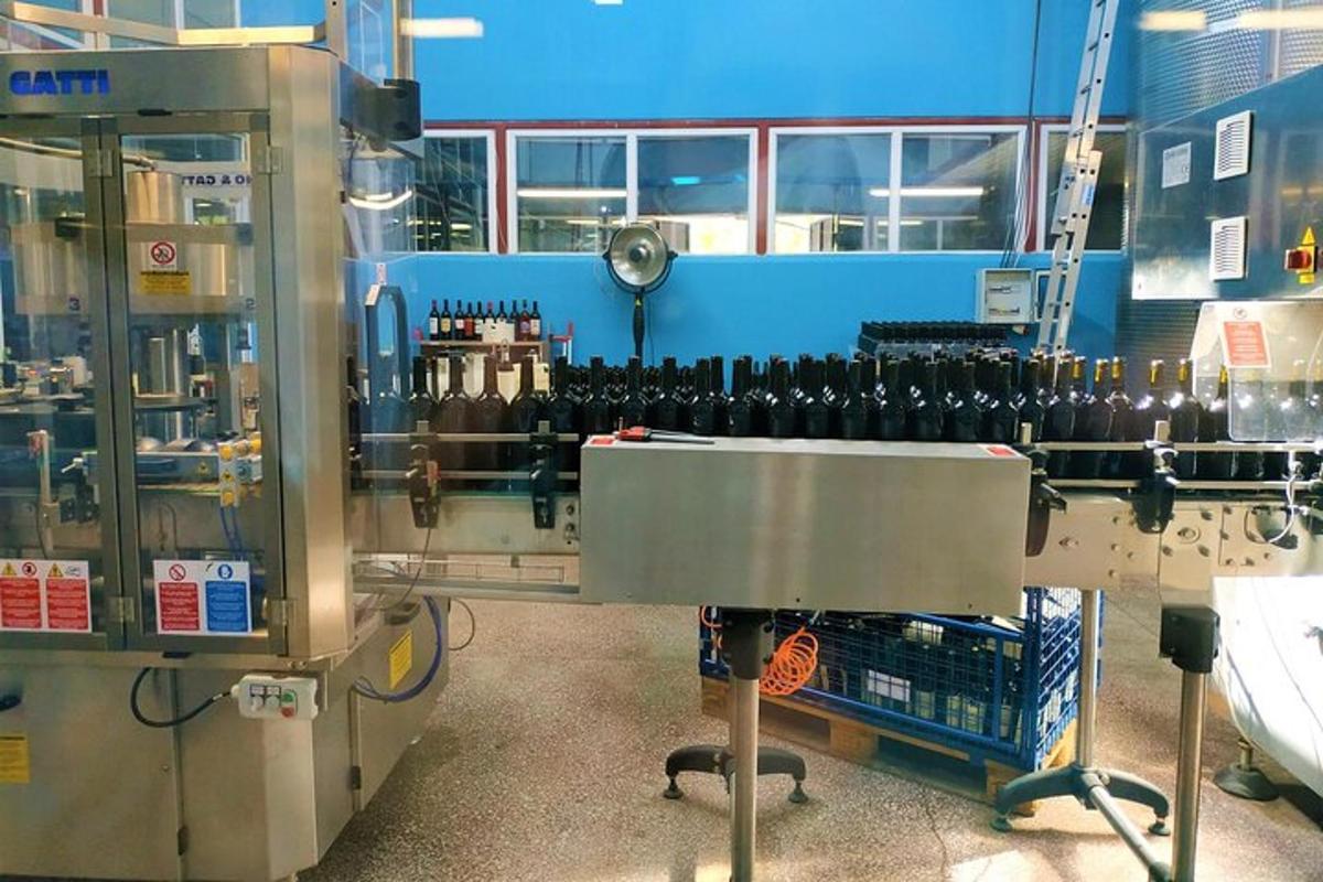 a wine making machine in a factory with wine bottles