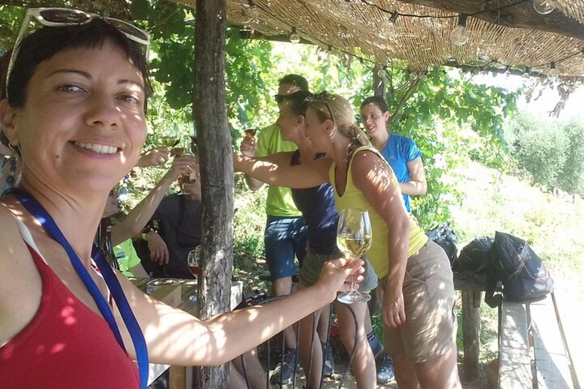una donna che tiene in mano un bicchiere di vino in un gruppo di persone