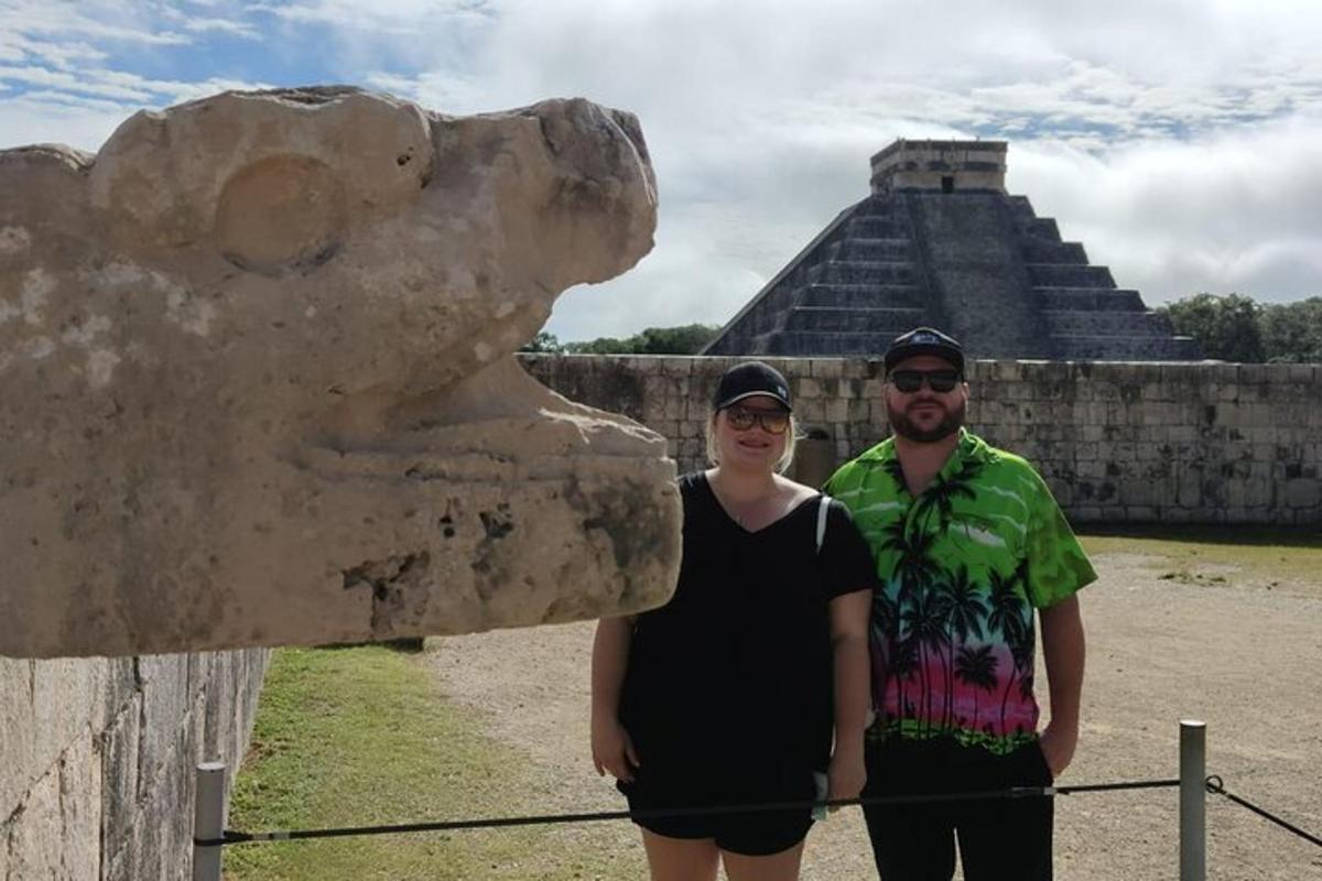 muž a žena stojící vedle sochy u pyramidy