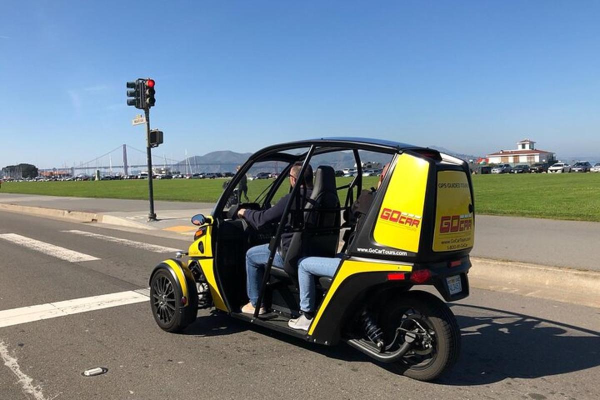 uma pessoa dirigindo um carrinho de golfe na estrada