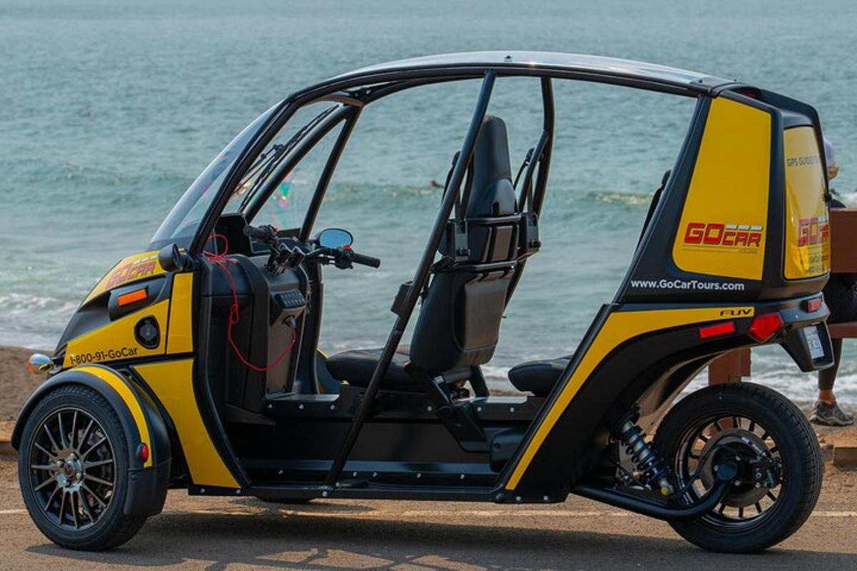 um carrinho de golfe amarelo e preto estacionado na praia