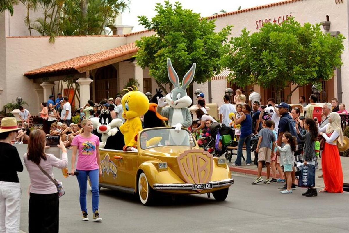 a group of people standing around a yellow car with two people in it