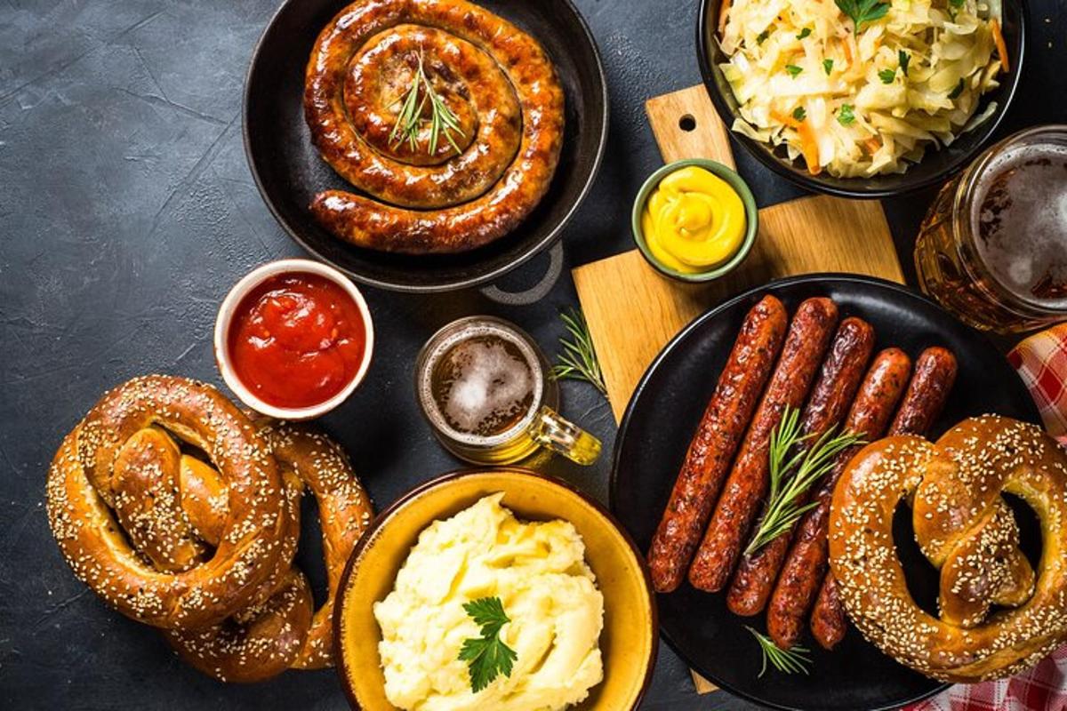 a table with plates of sausages onion rings and other food