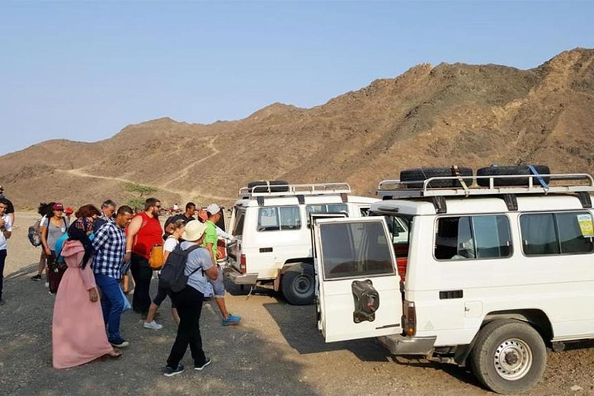 un gruppo di persone in piedi davanti ai loro veicoli