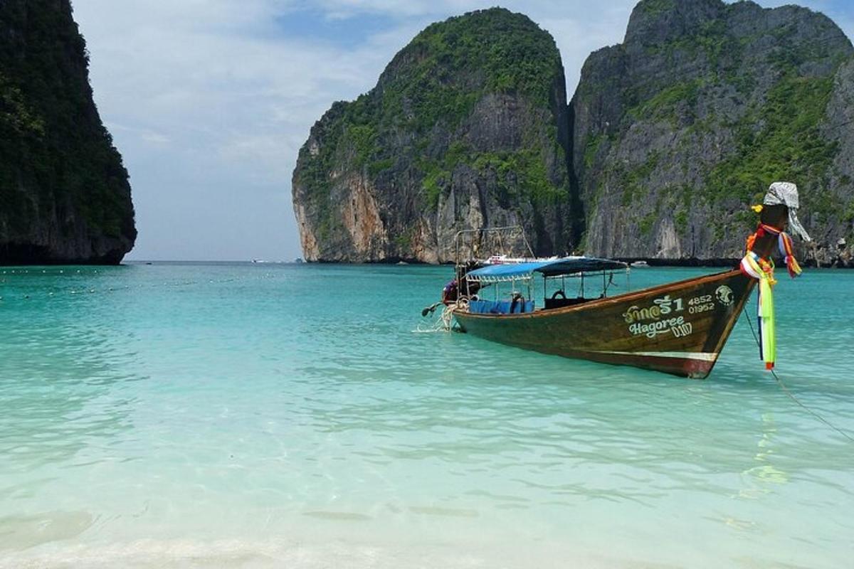 a boat sitting in the water near a beach