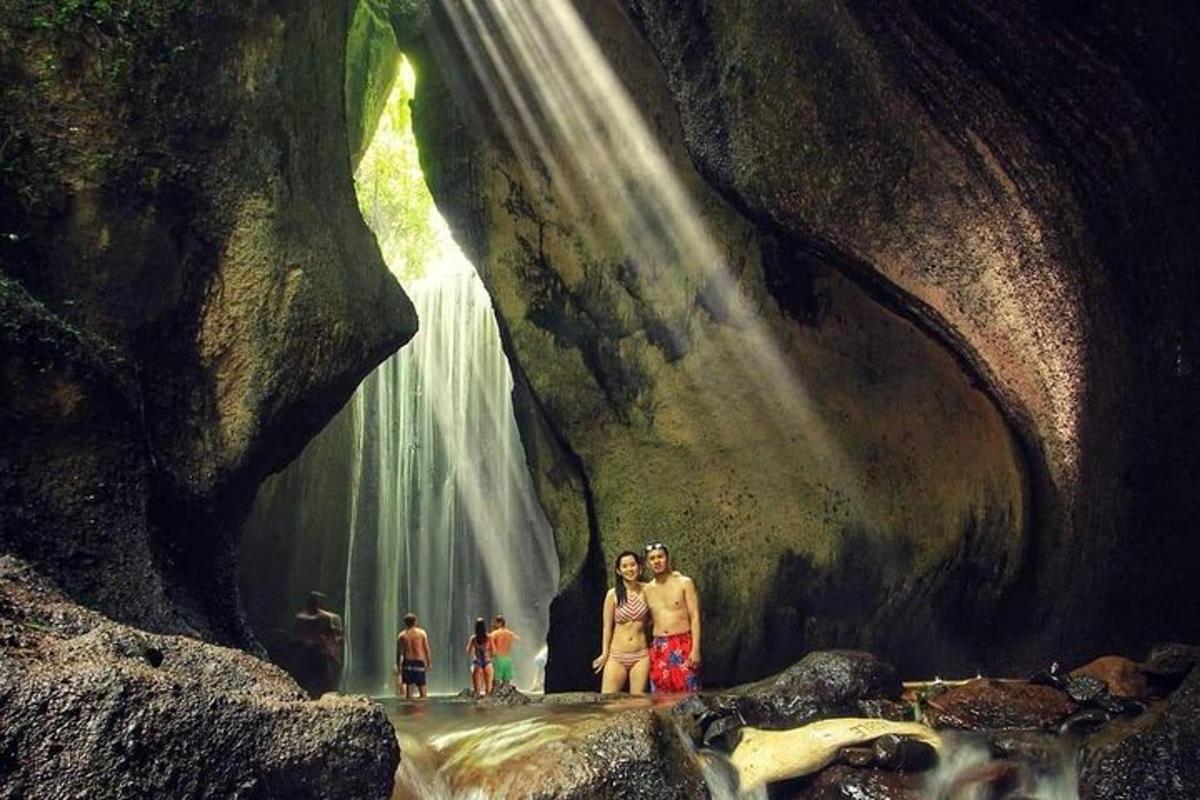 sekumpulan orang berdiri di hadapan air terjun