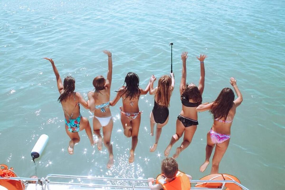 Un grupo de chicas saltando de un bote en el agua.
