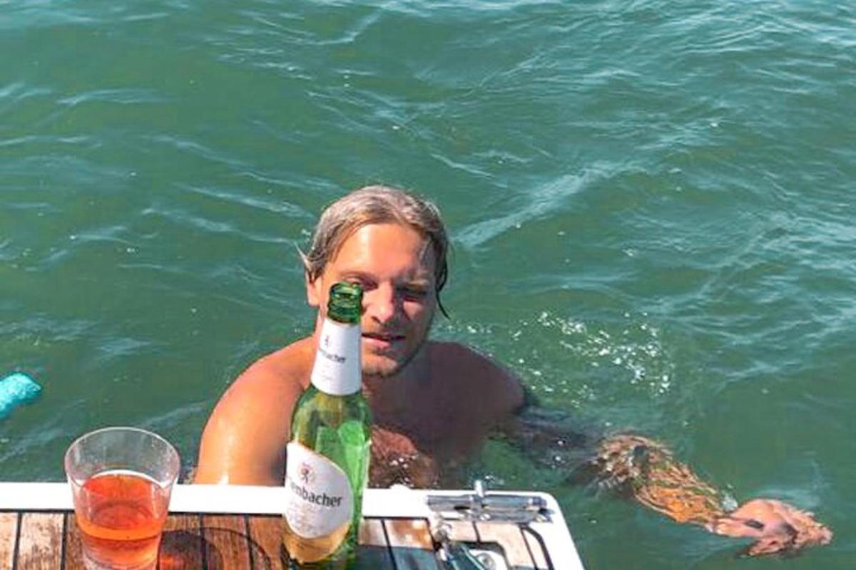 žena ve vodě s lahví vína