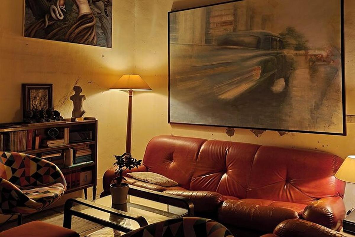 uma sala de estar com um sofá de couro marrom e uma pintura