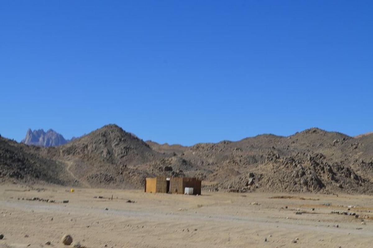 un edificio in mezzo a un deserto con montagne