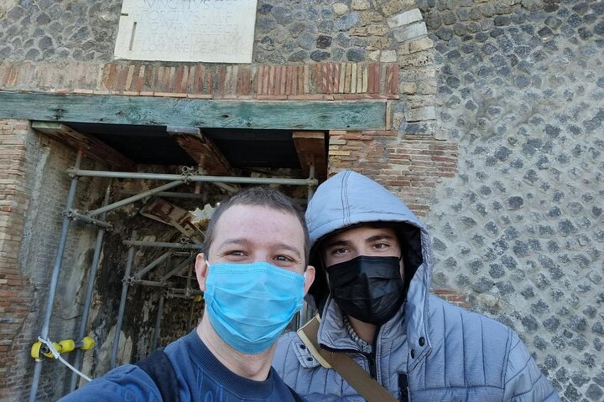 ένας άνδρας που φοράει μάσκα μπροστά από ένα κτίριο