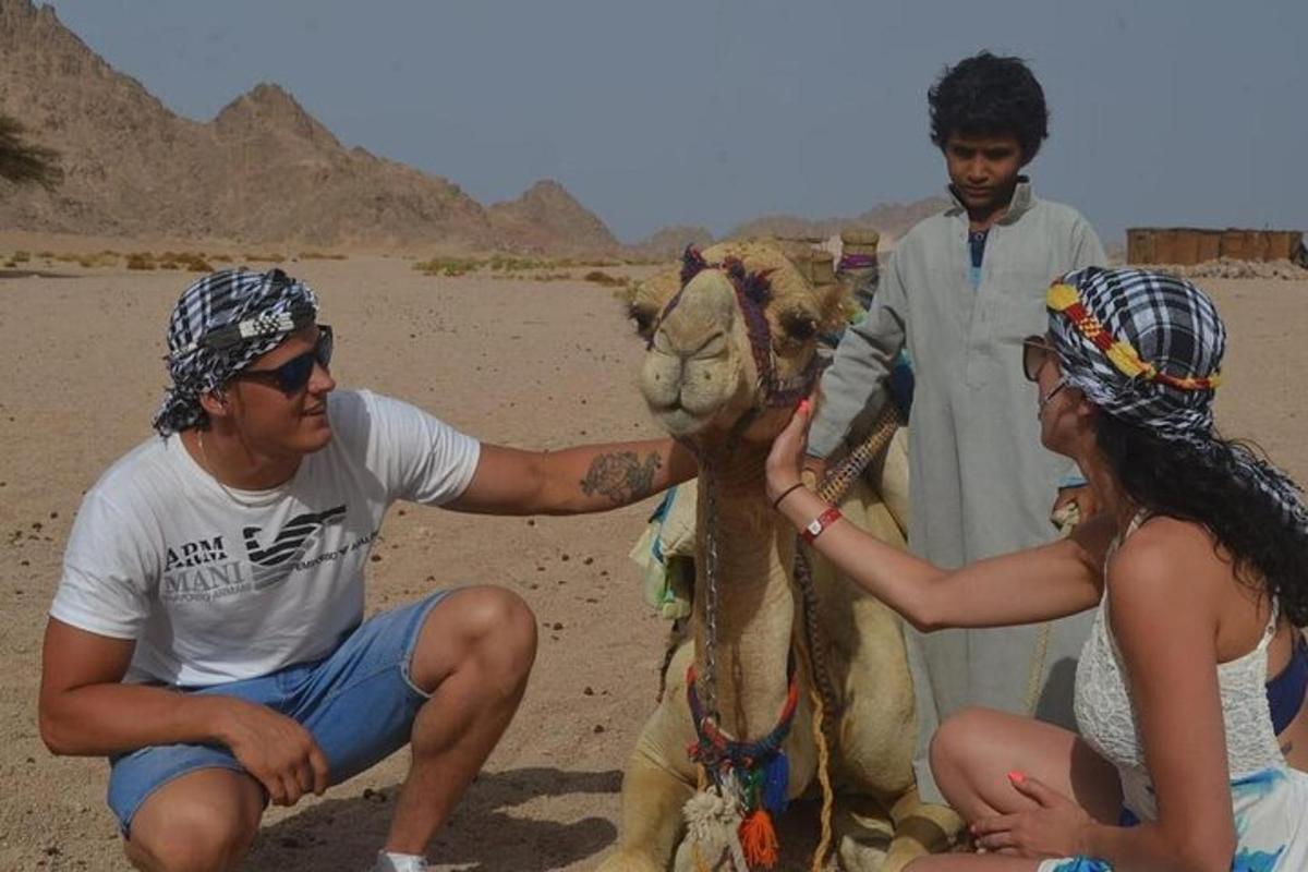 un uomo sta accarezzando un cammello nel deserto