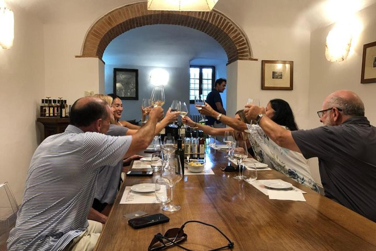 un grup de persones assegudes al voltant d'una taula amb copes de vi