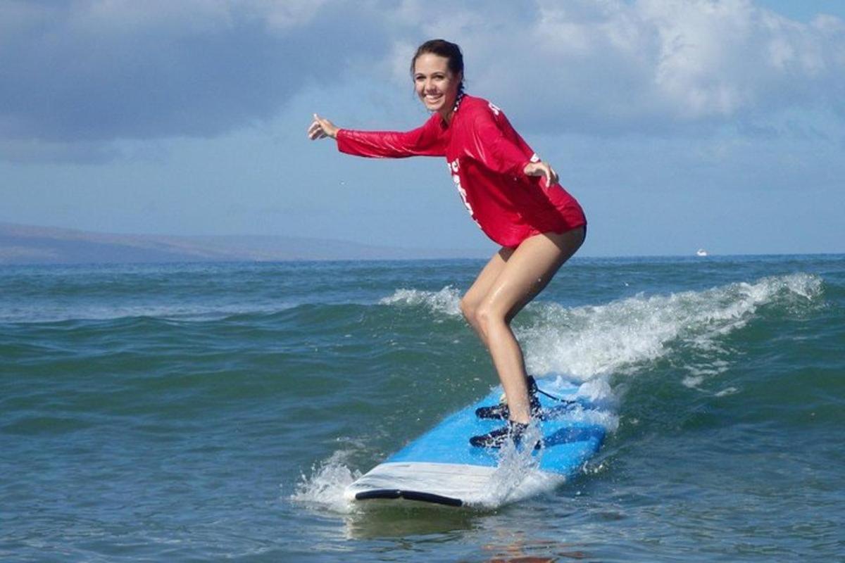eine Frau, die auf einem Surfbrett im Meer auf einer Welle reitet