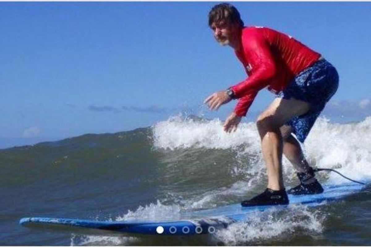 muž jedoucí na vlně na surfovém prkně v oceánu