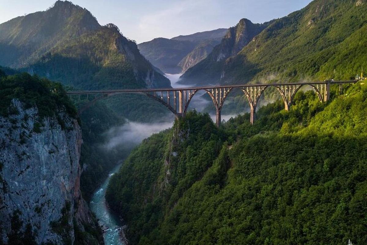 un puente sobre un río en un valle de montaña