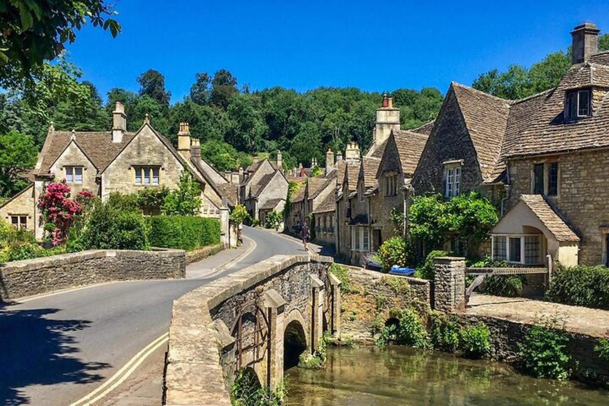 an old stone bridge over a street in a village