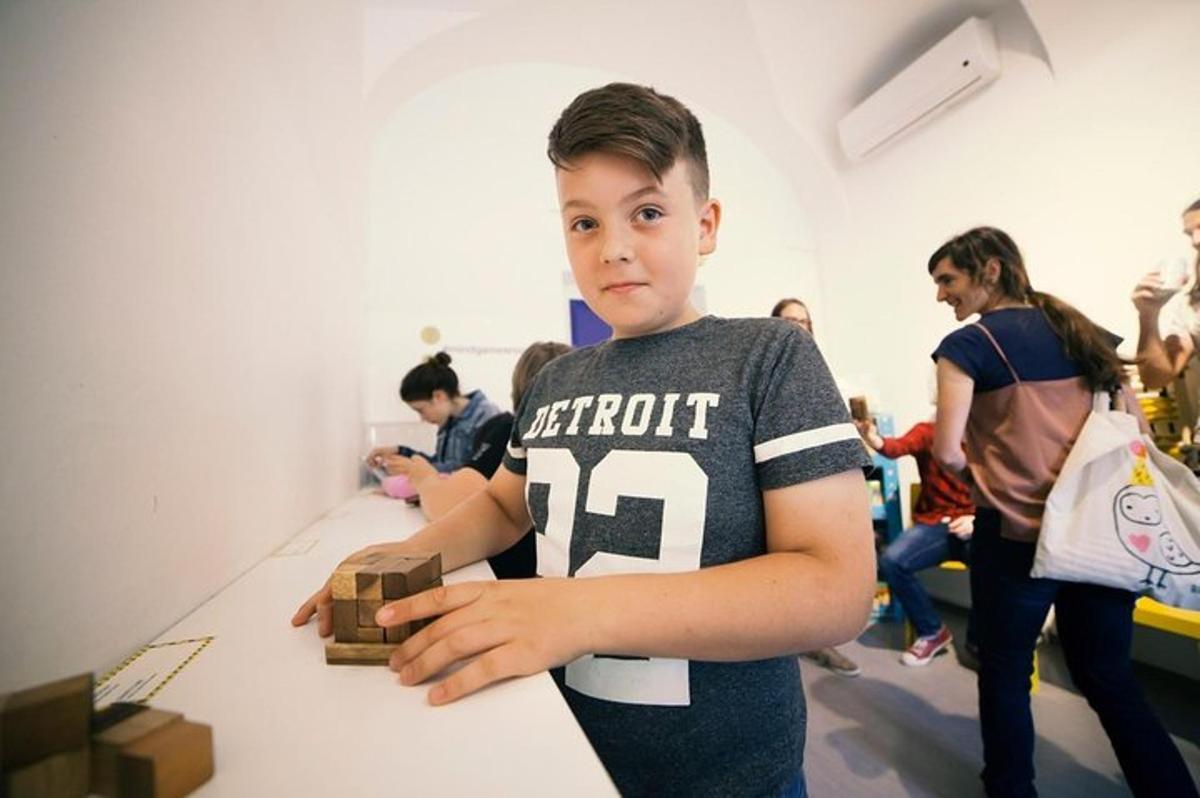 a young boy standing at a table playing with blocks