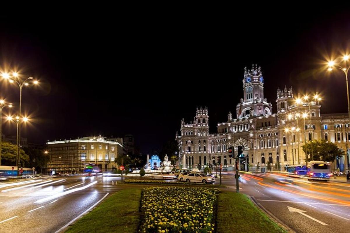 a city street at night with a large building