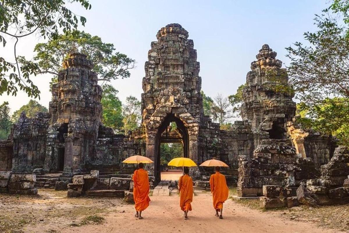 three monks walking in front of a temple with umbrellas