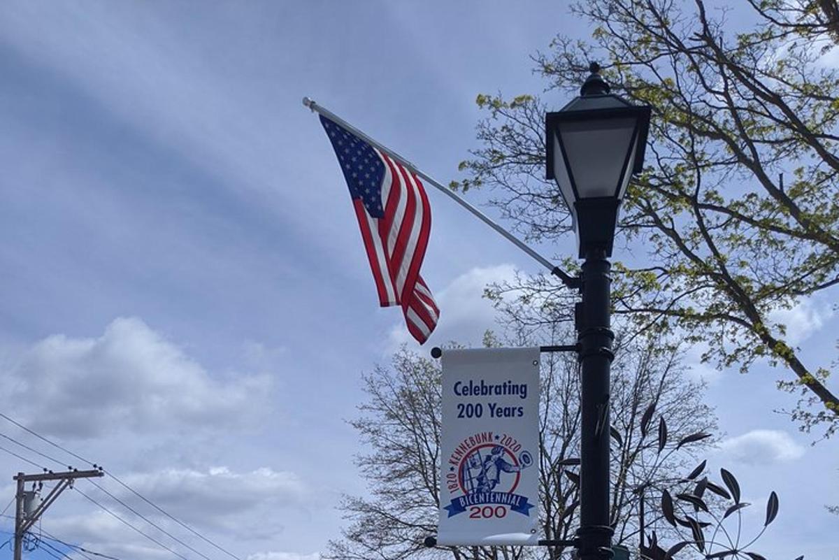 a flag and a sign next to a street light