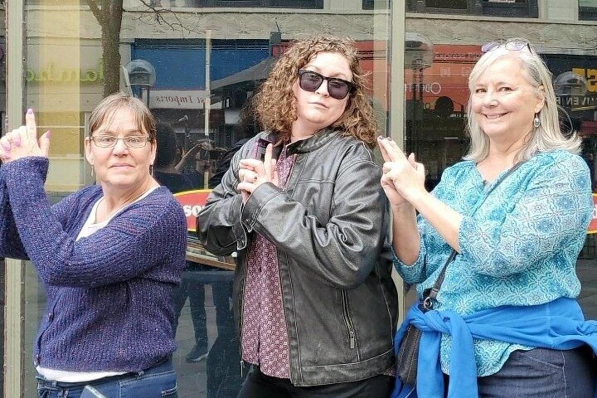 a group of three women standing next to each other