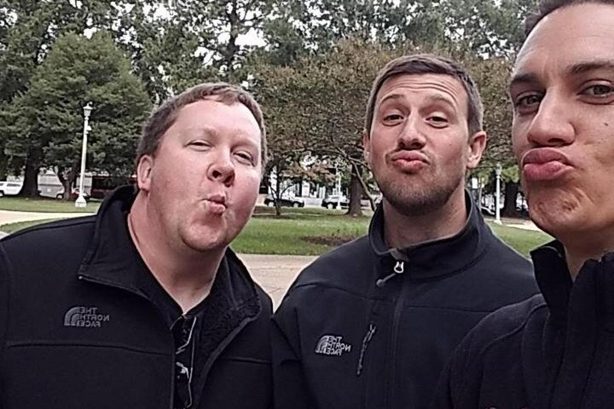 a group of three men standing next to each other