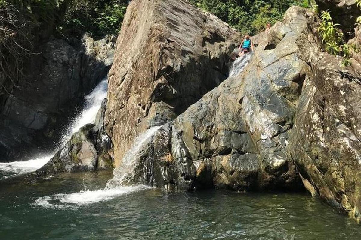 a person standing on a rock near a waterfall