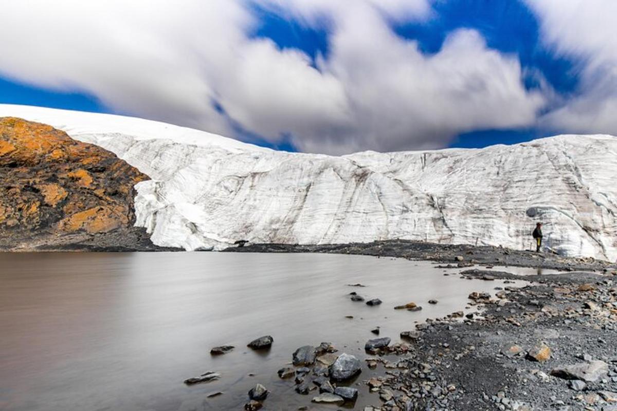 a person standing in front of a glacier