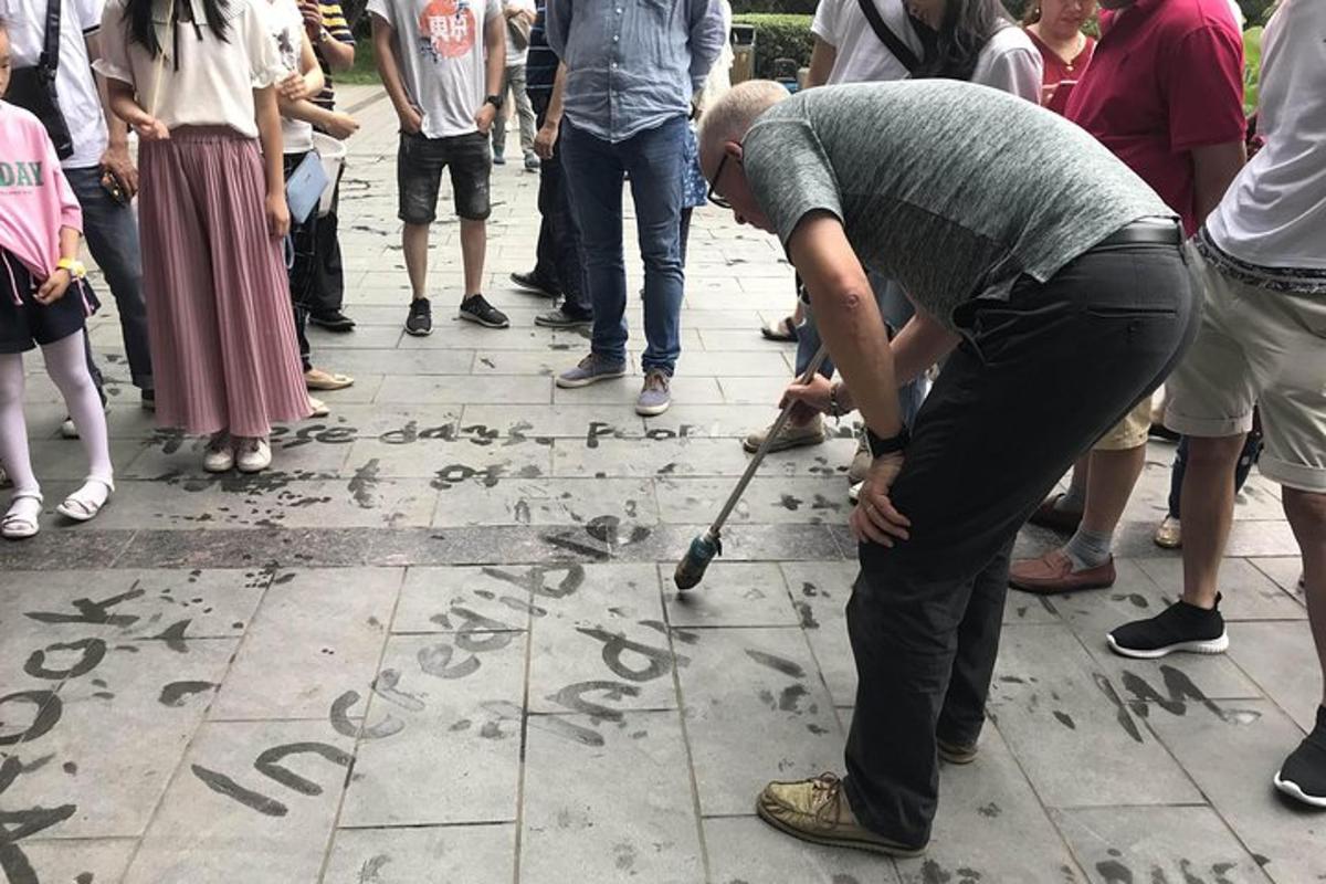 一名男子用棍子在地上写字