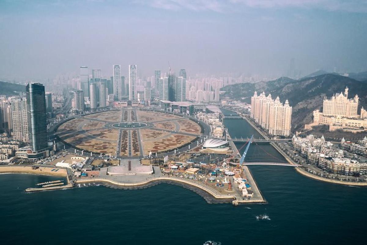 an aerial view of a city with a bridge over the water