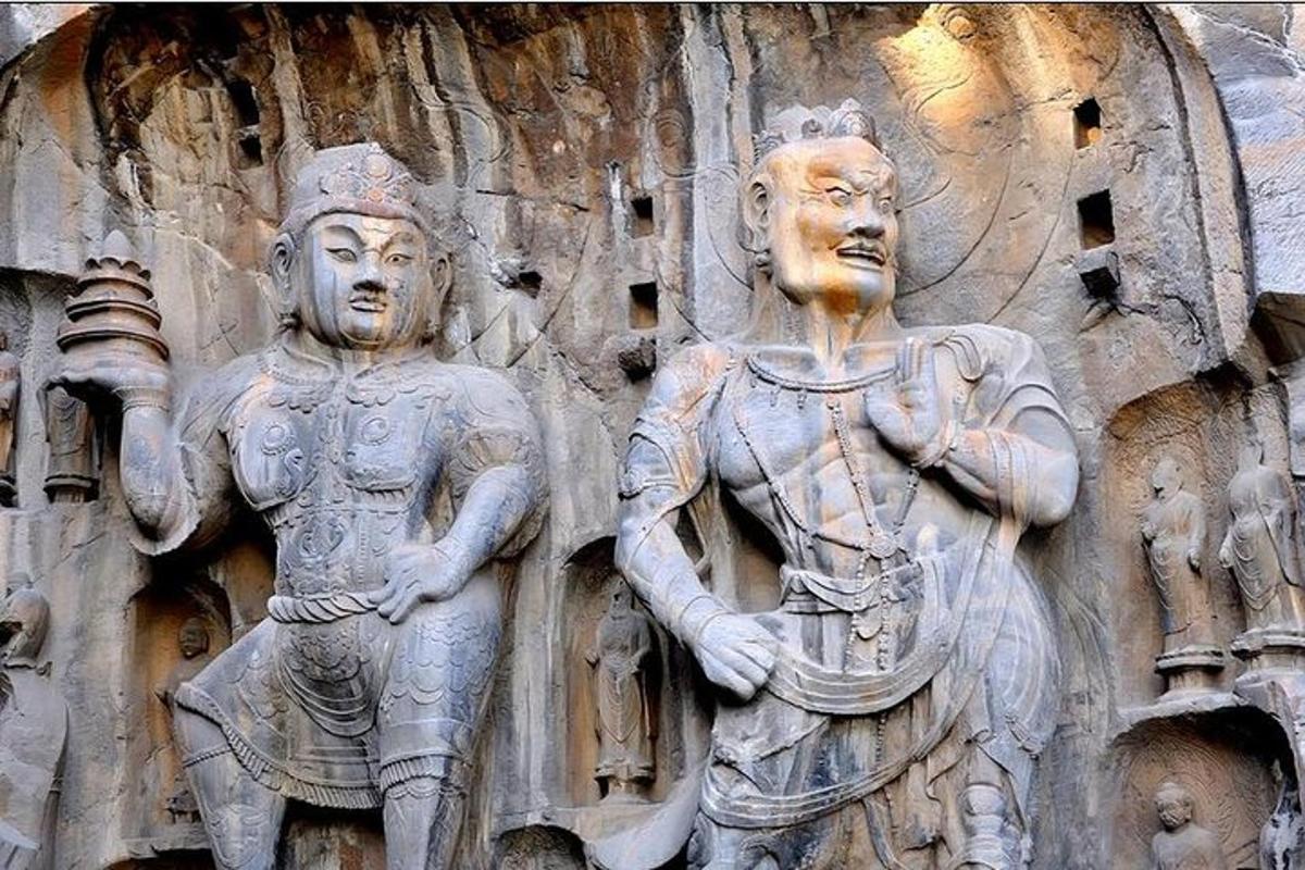a stone wall with two statues on it